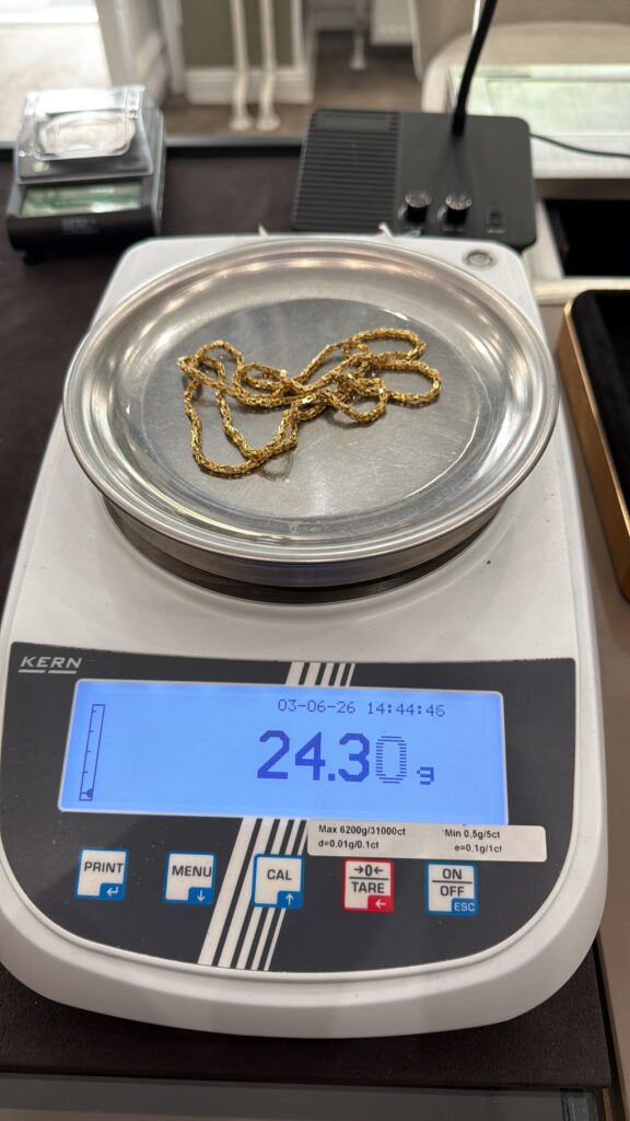 Gold Ankauf Preis wird ermittelt: Goldkette auf der Waage im Fachgeschäft in Berlin
