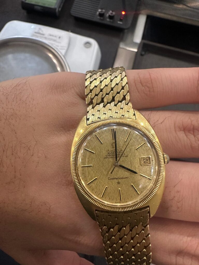 Golduhr verkaufen in Berlin: goldene Armbanduhr mit Goldband wird im Fachgeschäft geprüft