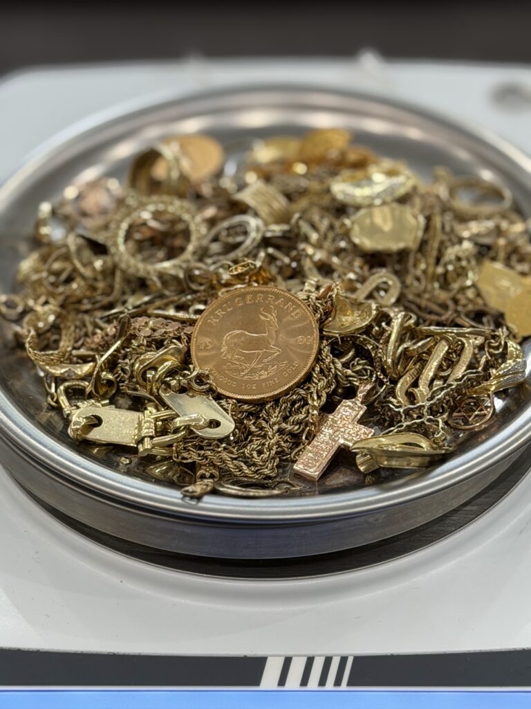 Markenschmuck verkaufen in Berlin: Goldschmuck und Krügerrand auf der Waage der Goldankaufstelle